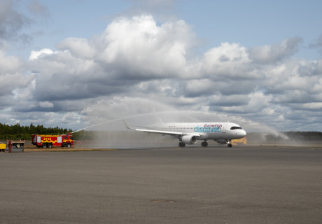 Eurowings discovery flygplan som landar för första gången med årets charterresor på Jönköping Airport som spolas med en ridå av vatten av flygplatsens räddningstjänst.